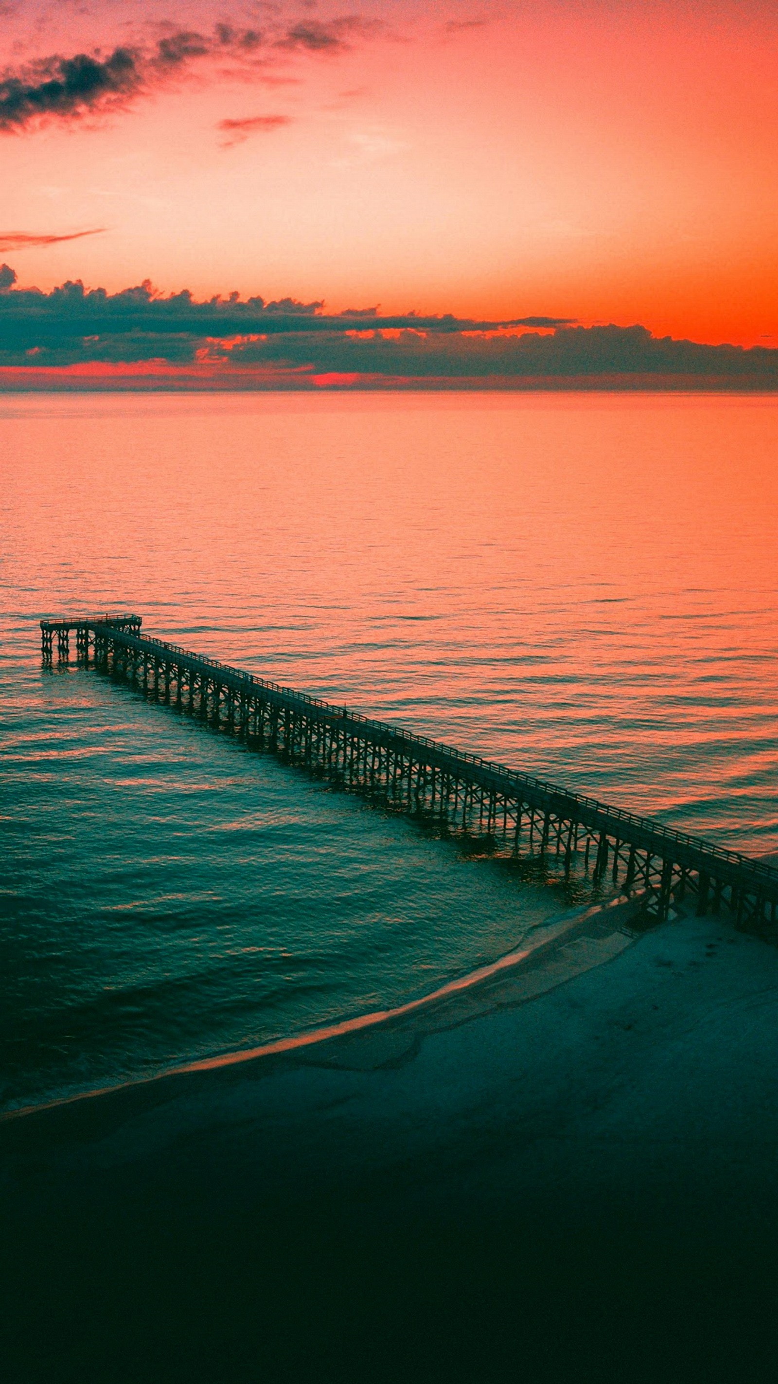 Steg im ozean bei sonnenuntergang mit rosa himmel (wasser, wolke, wasserressourcen, atmosphäre, nachglühen)