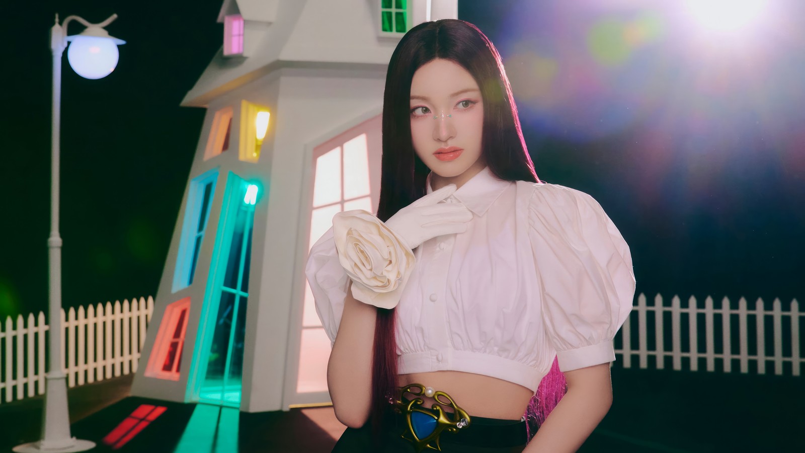 Une femme en blouse blanche et jupe noire pose devant une maison (ive, kpop, 아이브, coréen, groupe de filles)