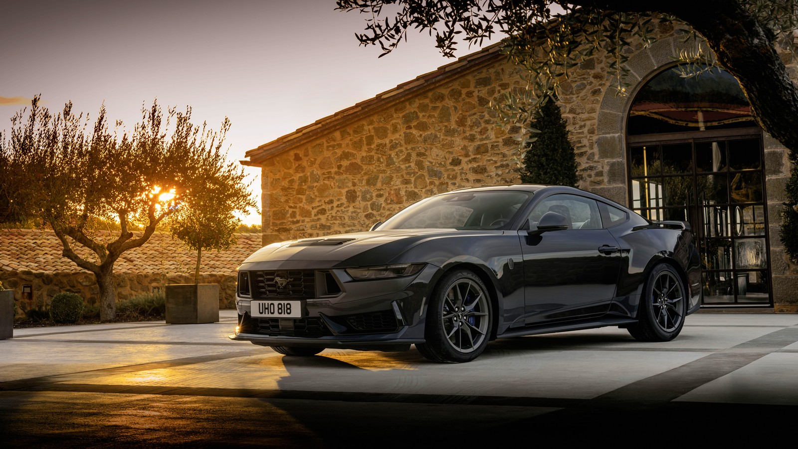 Der neue aston vantage wird vor einem steingebäude gezeigt (ford mustang dark horse, sonnenuntergang, 2024, autos, 4k hintergrund)