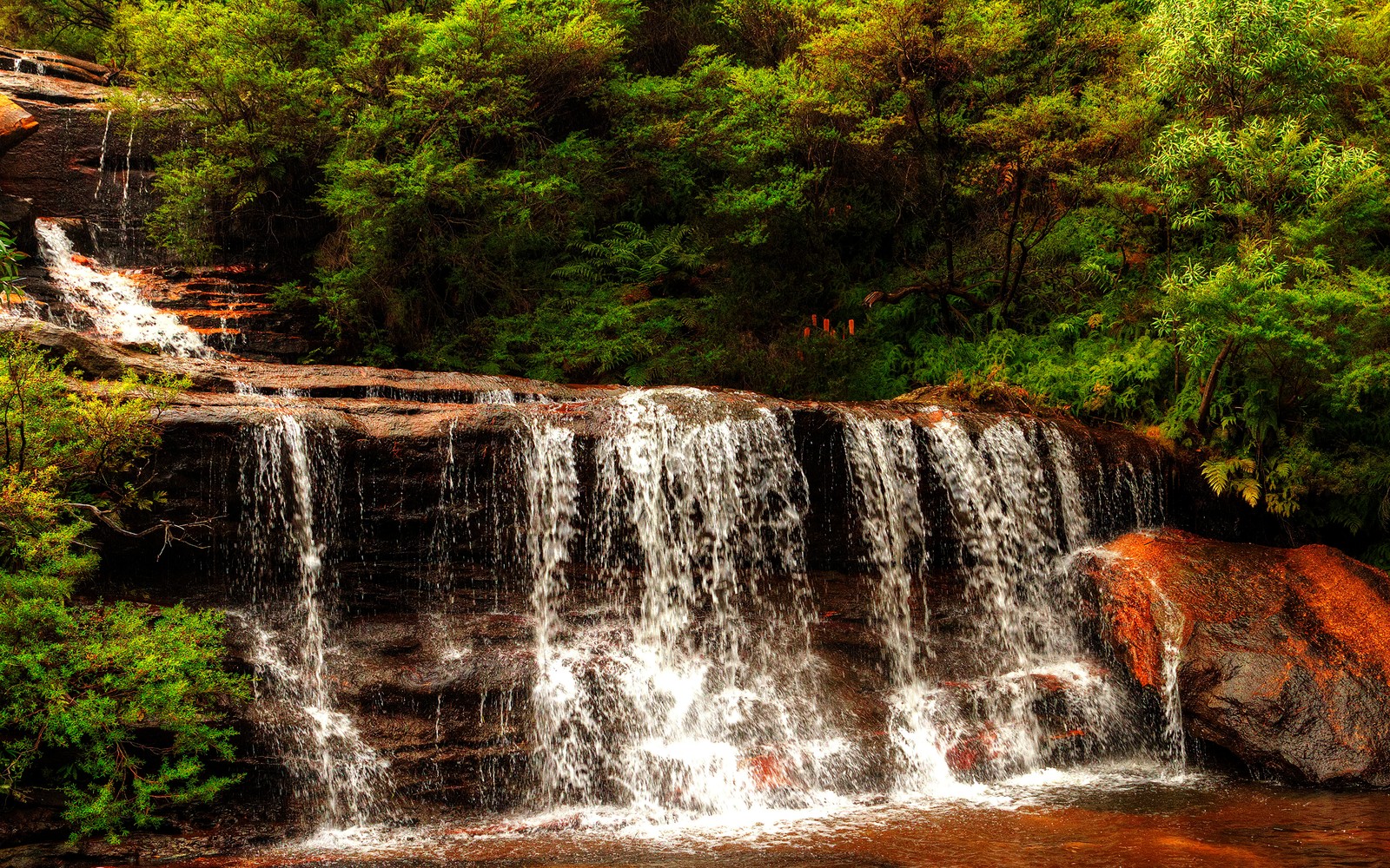 Un primer plano de una cascada con una persona de pie sobre una roca (cascadas wentworth, cascada, recursos hídricos, cuerpo de agua, naturaleza)