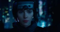 Scarlett Johansson en tant que Major Motoko Kusanagi, illuminée par des lumières néon, dans un paysage urbain sombre et futuriste de "Ghost in the Shell".