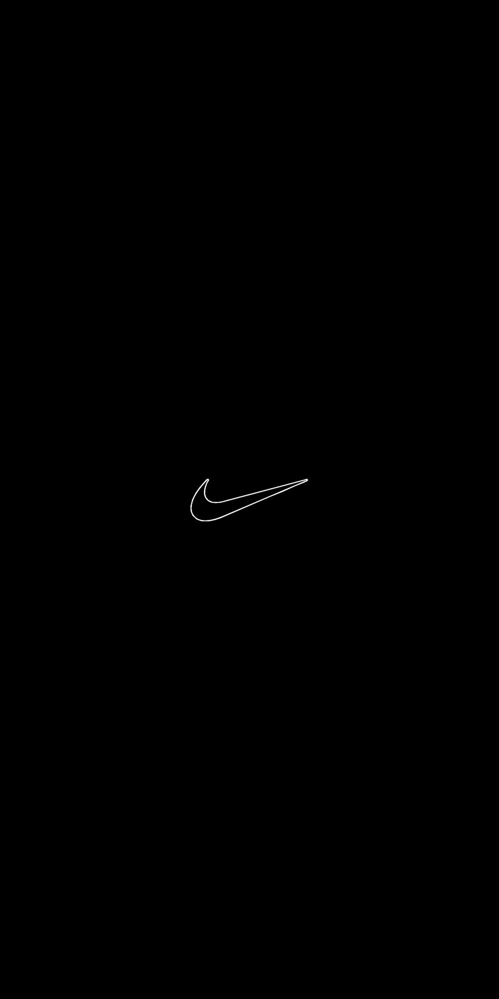 Une image floue d'un avion volant dans le ciel sombre (noir, marque, logo, nike, blanc)