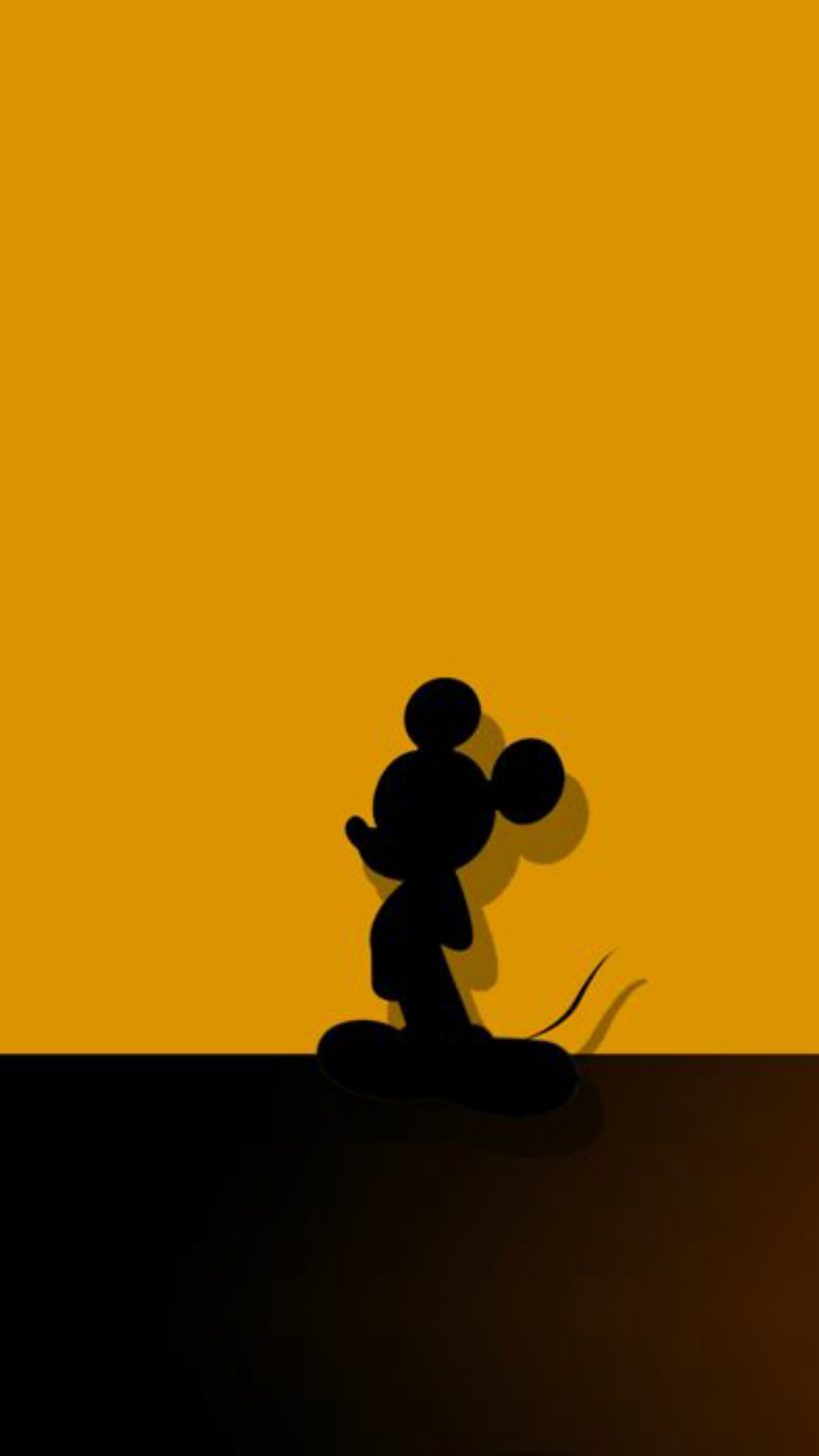 Mickey mouse silhouettiert vor einem gelben hintergrund mit einem schwarzen hintergrund (disney, micky, maus, walt)