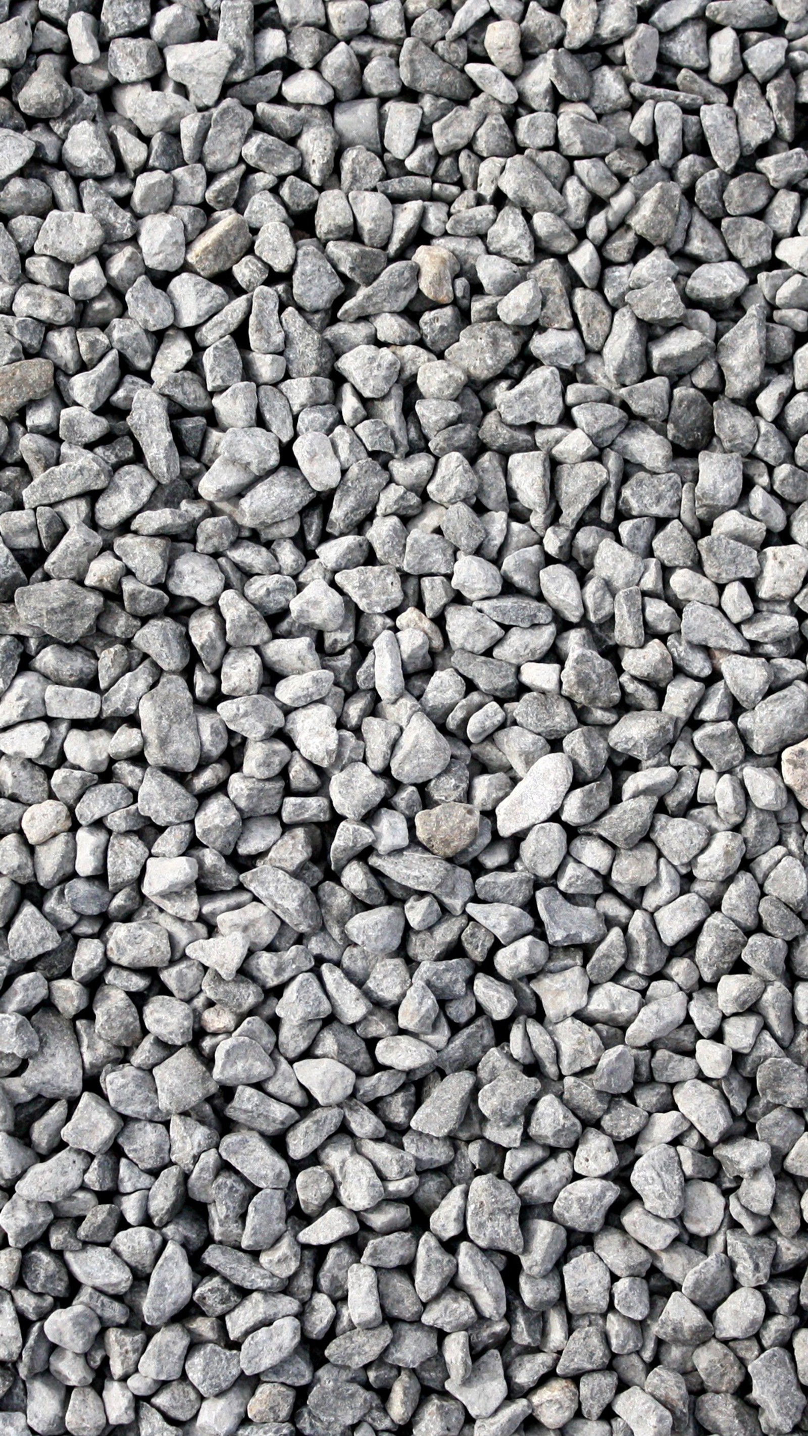 A close up of a pile of rocks with a red fire hydrant (black, gravel, road, rocks, white)