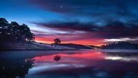 Pôr do sol tranquilo sobre um lago sereno com céus refletivos