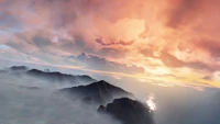 Amanhecer sobre as cristas das montanhas sob nuvens dramáticas