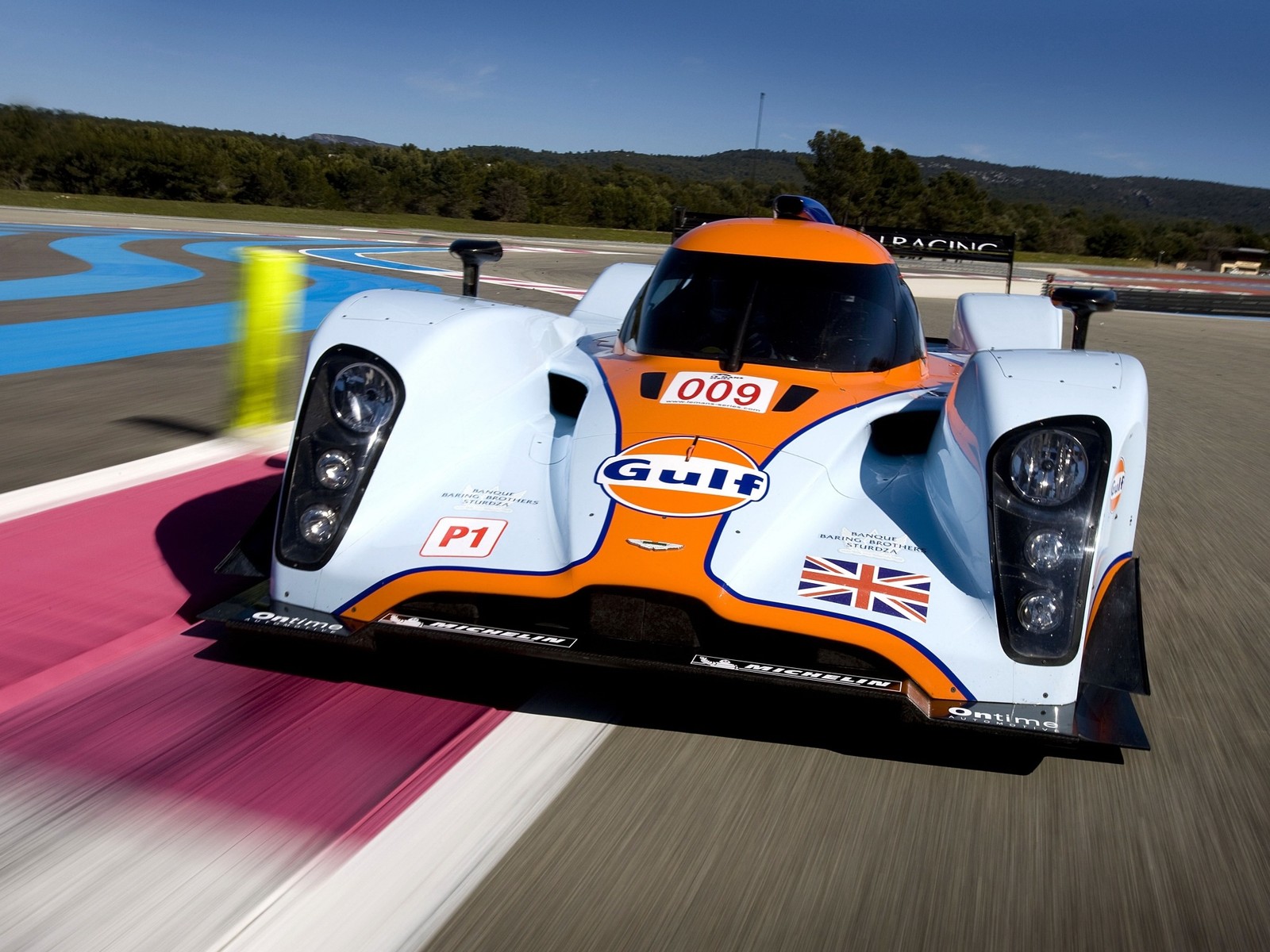 A close up of a race car driving on a track (aston martin, race car, sports car racing, sports prototype, aston martin one 77)