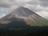 Majestuoso estratovolcán rodeado de exuberantes tierras altas y cielos dramáticos