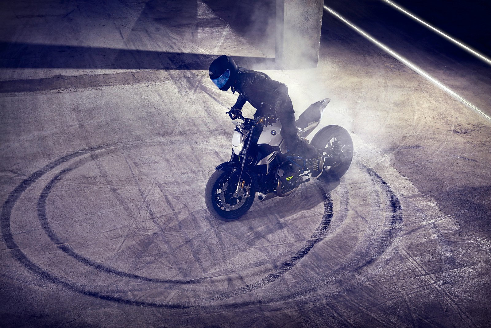 Arafed man riding a motorcycle on a track in a parking lot (motorcycle, roadster, stunt performer, stunt, extreme sport)