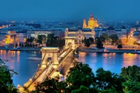 Beleuchtete Széchenyi-Kettenbrücke und das ungarische Parlamentsgebäude, die sich nachts auf der Donau spiegeln