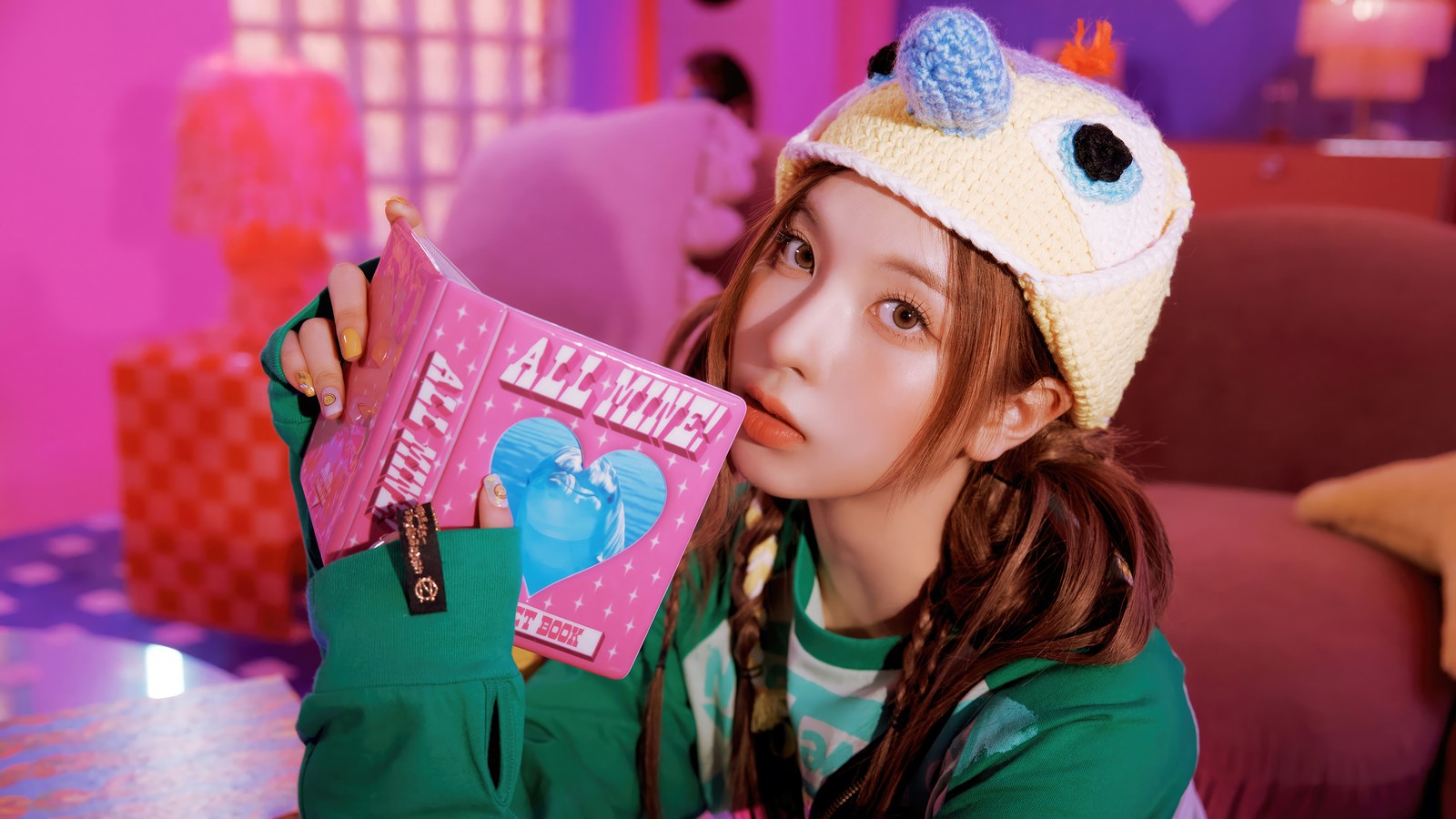 Une girafe avec un chapeau tenant un livre dans sa main (nmixx, kpop, k pop, filles, groupe de filles coréen)