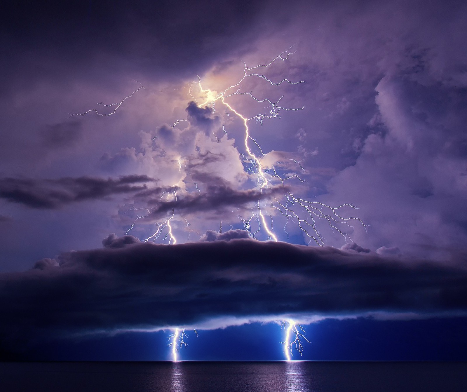 Lightning strikes from a cloud over the ocean during a storm (lightning, nature, space)