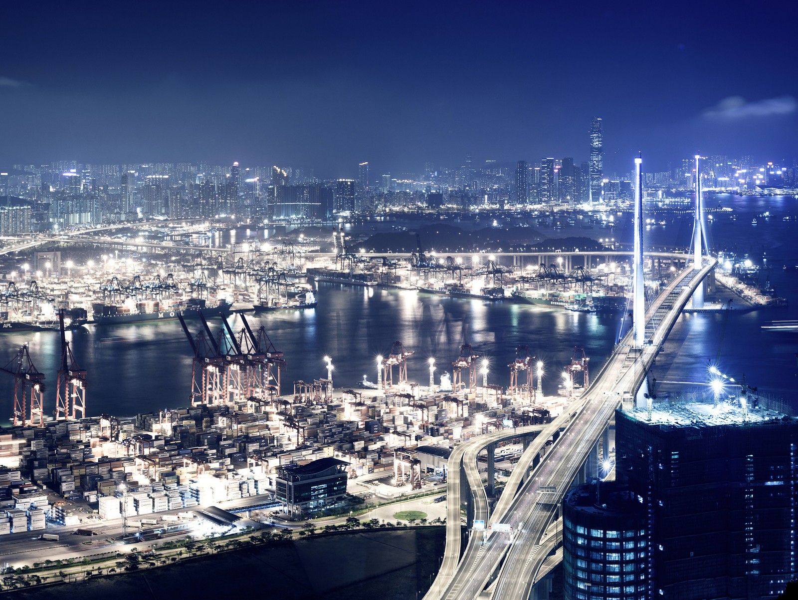 Vista aérea de una ciudad de noche con un puente y un río (puente, ciudad, alto, ligero, océano)