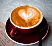 Art latte en forme de cœur dans une tasse à café rouge