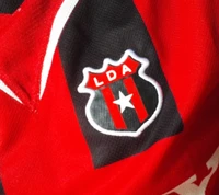 Emblema del club LDA Alajuelense en tela roja