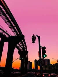 Silueta de paisaje urbano bajo un cielo rosa al anochecer