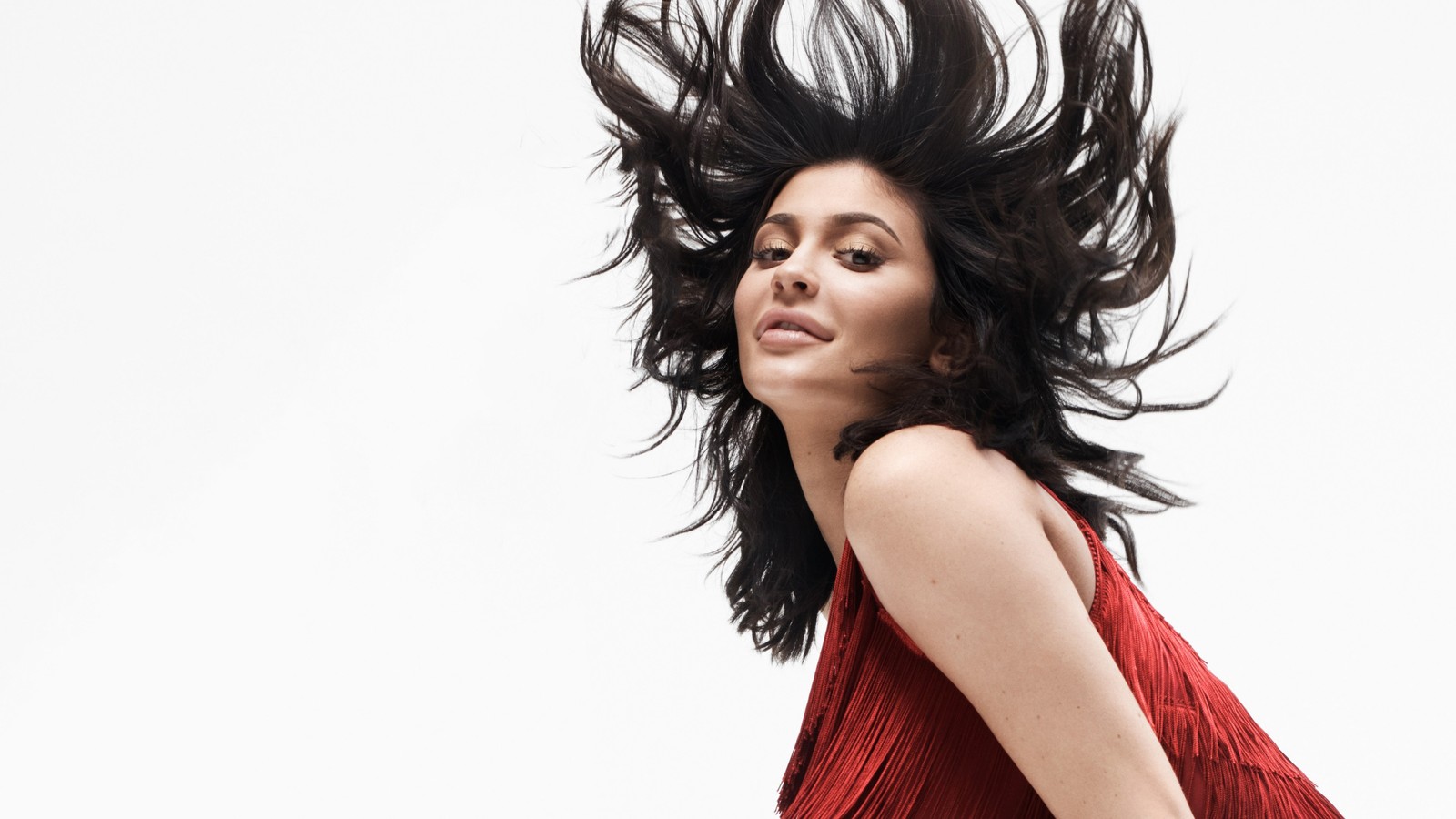 Une femme en robe rouge avec les cheveux au vent (célébrité, lèvre, cils, rouge à lèvres, cou)