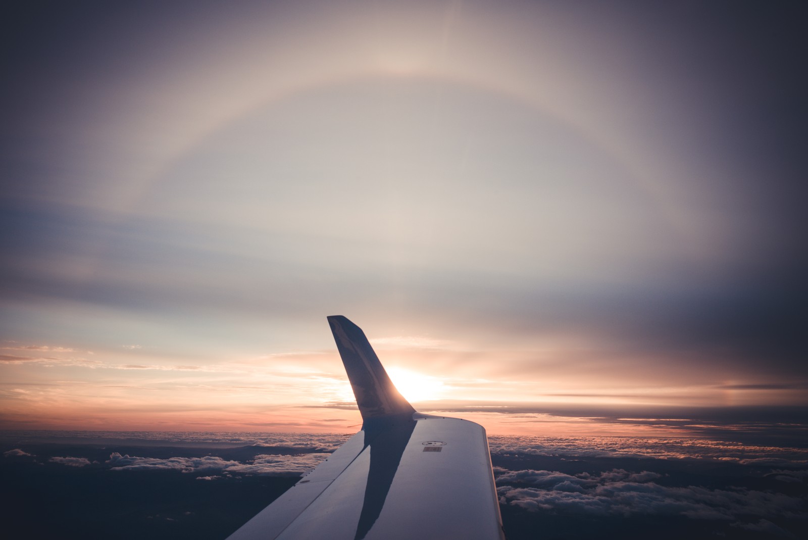 Uma vista da asa de um avião com o sol se pondo ao fundo (aeronave, aviação, viagem aérea, linha aérea, asa)