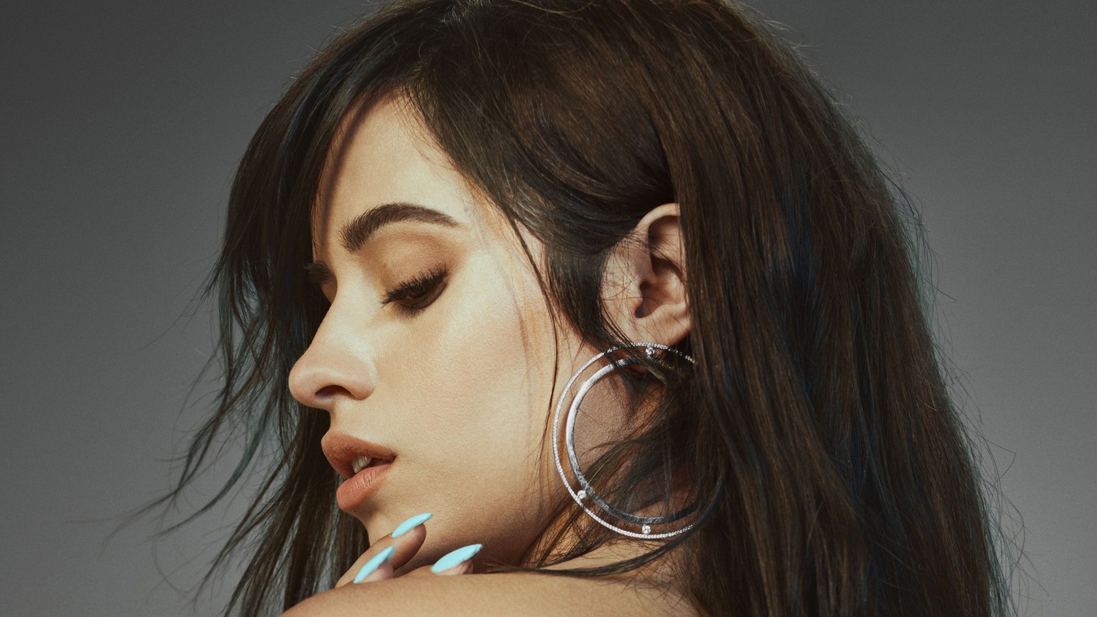 Une femme avec de longs cheveux et des boucles d'oreilles créoles posant pour une photo (camila cabello, chanteur, célébrité, femmes, filles)