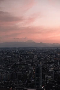 Paisaje urbano al anochecer con montañas distantes