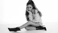 Ariana Grande in einer auffälligen Schwarz-Weiß-Pose, die Eleganz und Attitüde zeigt.