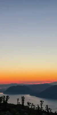 Sereno crepúsculo sobre el horizonte montañoso con cálidos tonos de atardecer