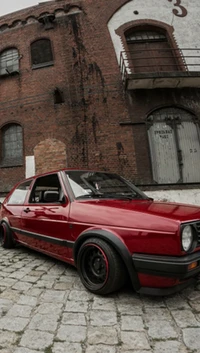 Stylisches rotes Auto vor historischem Lagerhaus geparkt