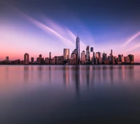 Pôr do sol sereno sobre um horizonte da cidade refletido em águas calmas