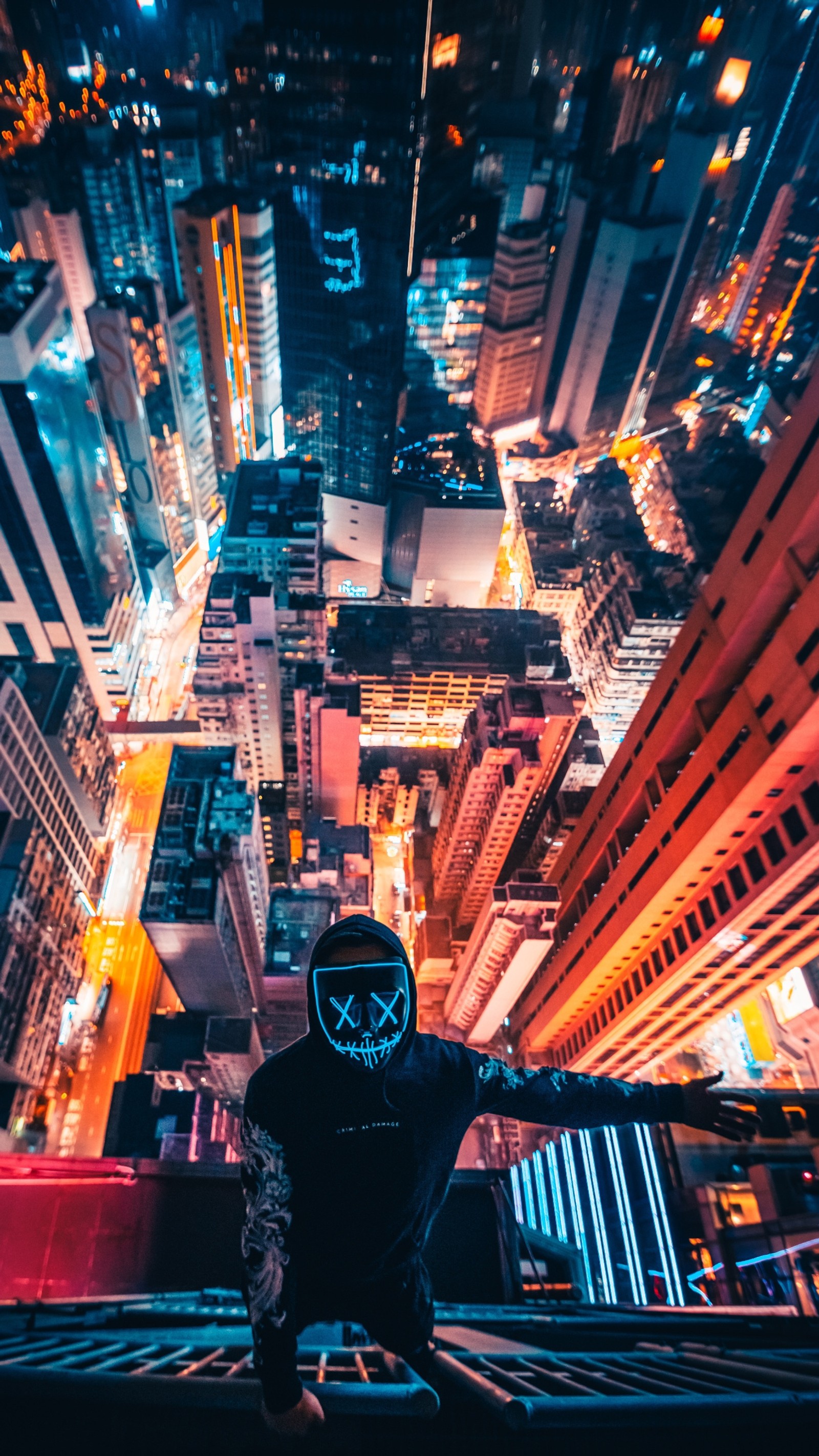 A person standing on a ledge looking down at a city at night (air, city, selfie, 4k, lights)