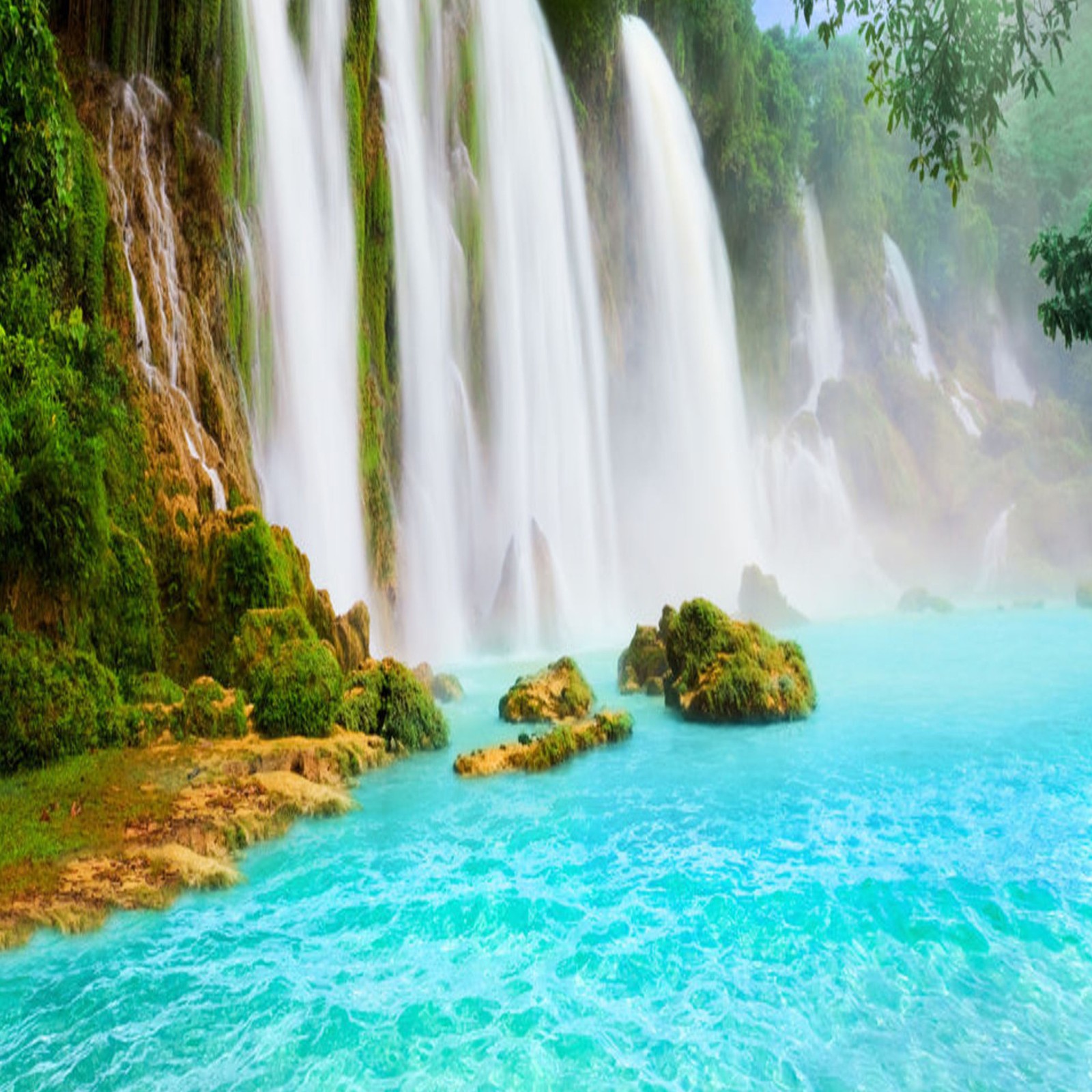 Um close de uma cachoeira com água azul e árvores verdes (paisagem, natureza, cachoeiras)