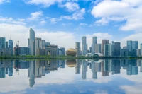 Modern Skyscrapers Reflecting in Tranquil Water Under a Bright Sky