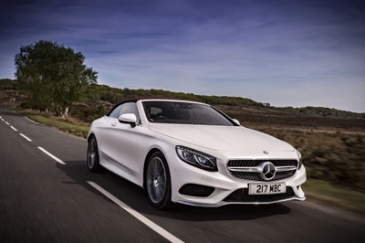 Elegante conversível branco da Mercedes-Benz em uma estrada cênica.