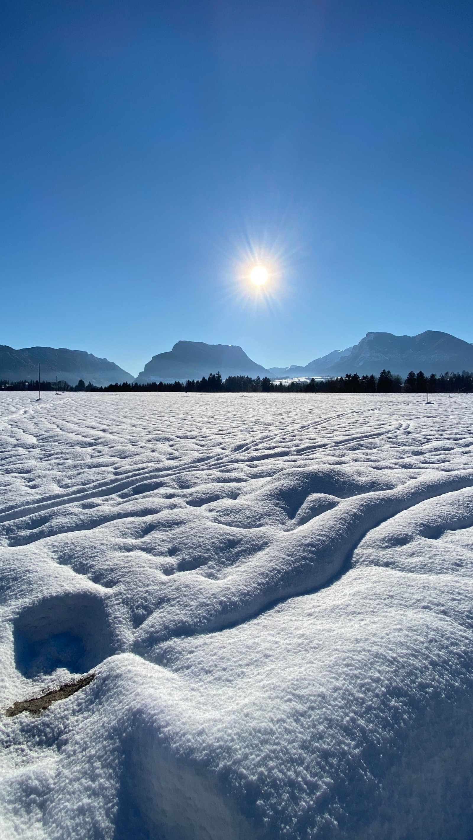 Arafed snow covered field with a sun shining over the mountains (winter, landscape, atmosphere, mountain range, sun)