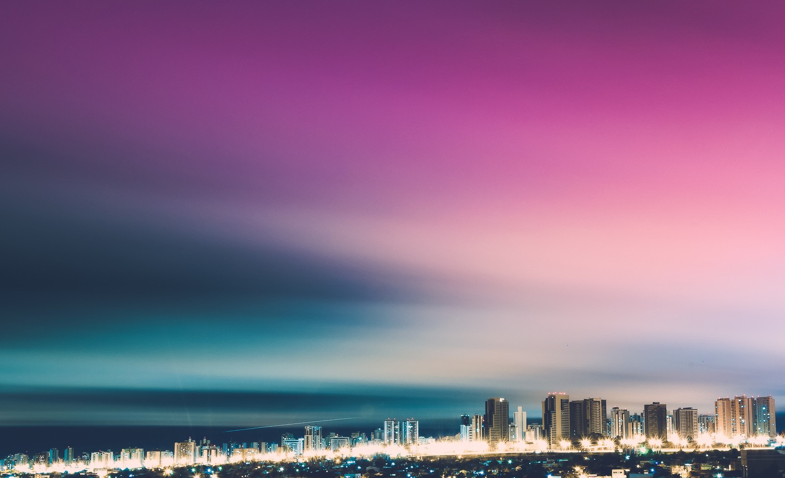 Vista aérea de uma cidade à noite com um céu rosa (paisagem urbana, cidade, azul, área urbana, dia)