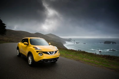 Желтый Nissan Juke кроссовер на прибрежной дороге с драматичными небесами