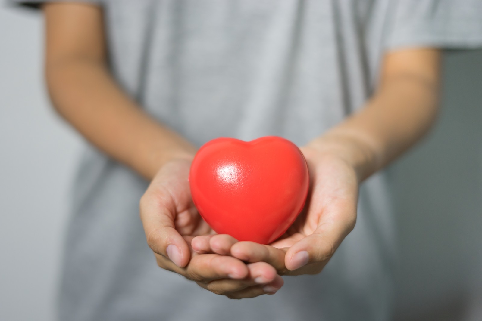 Quelqu'un tenant un cœur rouge dans ses mains (cœur, thérapie, rouge, main, ballon)