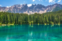 Lago tranquilo de los Dolomitas rodeado de exuberantes bosques de alerces y majestuosas montañas