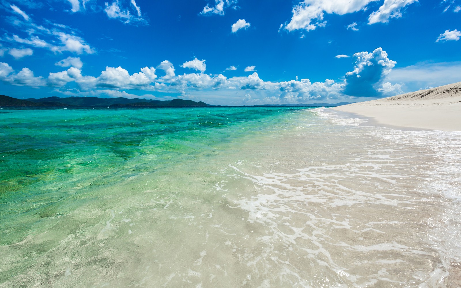 A view of a beach with clear water and a blue sky (sandy cay island, british virgin islands, caribbean sea, seascape, clouds)