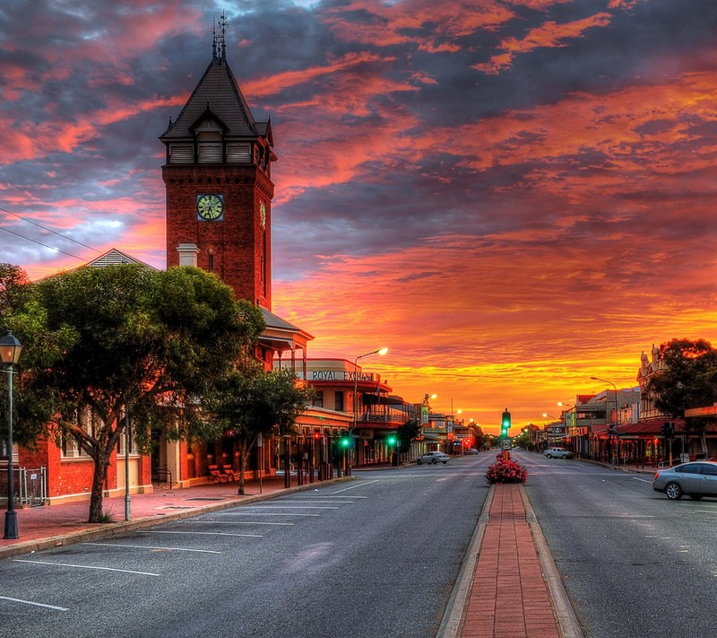 Atardecer sobre una calle de la ciudad con una torre del reloj a lo lejos (amor, espacio)