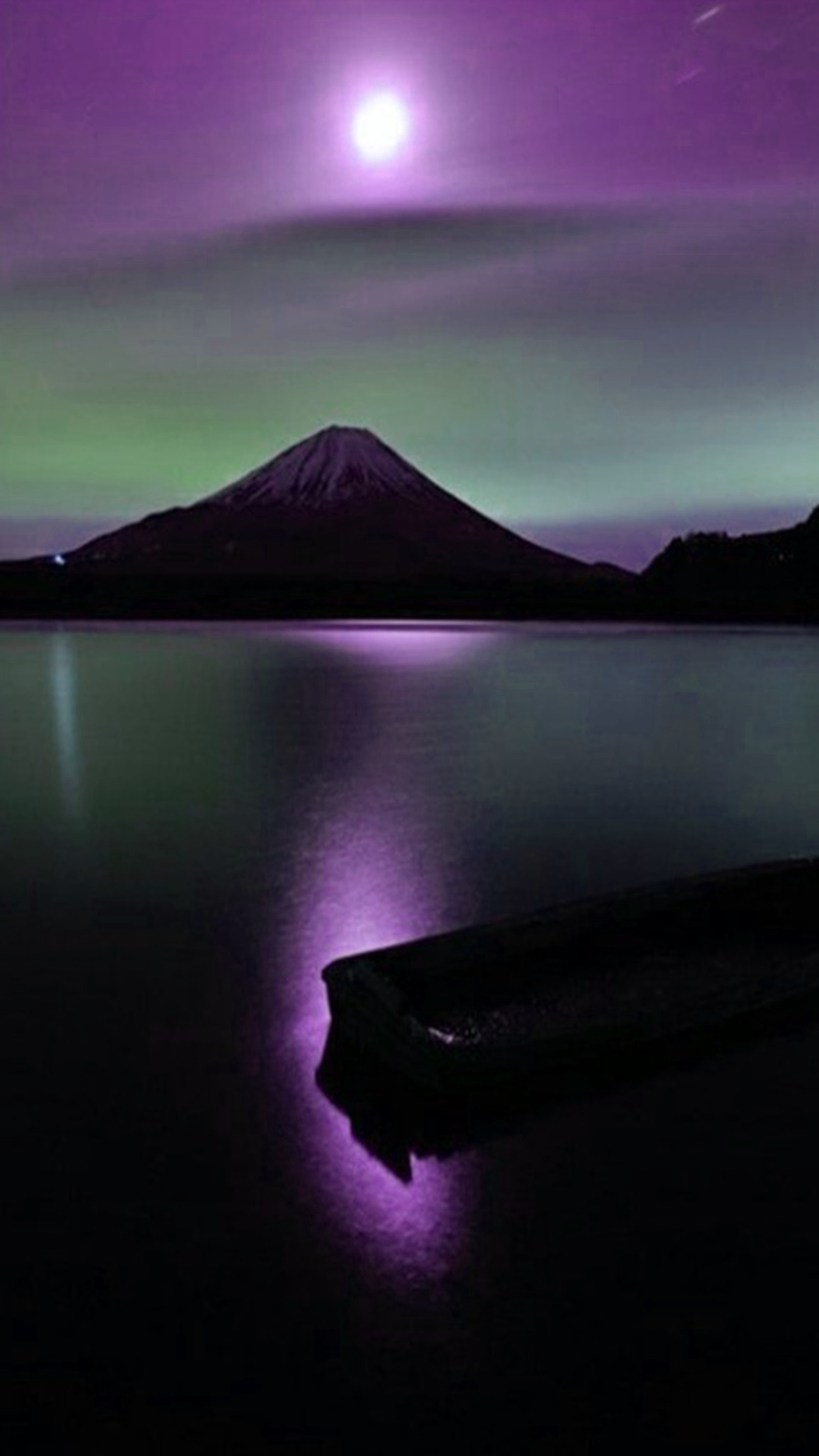 Arafed mountain in the distance with a purple sky and a purple light (landscape, nature)