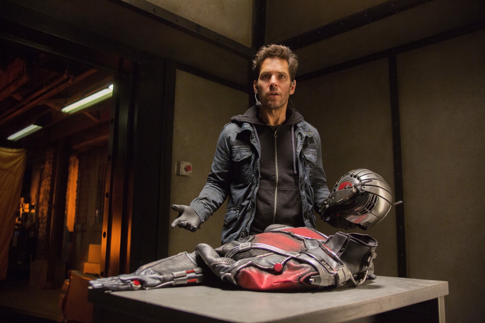 Homem árabe com uma jaqueta preta e um capacete vermelho em pé sobre um homem morto (ant man, universo cinematográfico da marvel, marvel cinematic universe, filme, ator)