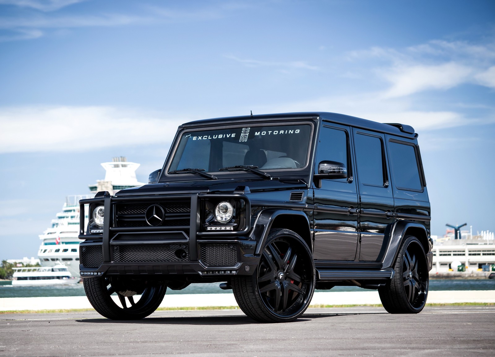 Um close em um mercedes g-class preto estacionado em um estacionamento (carro, roda, jeep, mercedes amg, mercedes benz g class)