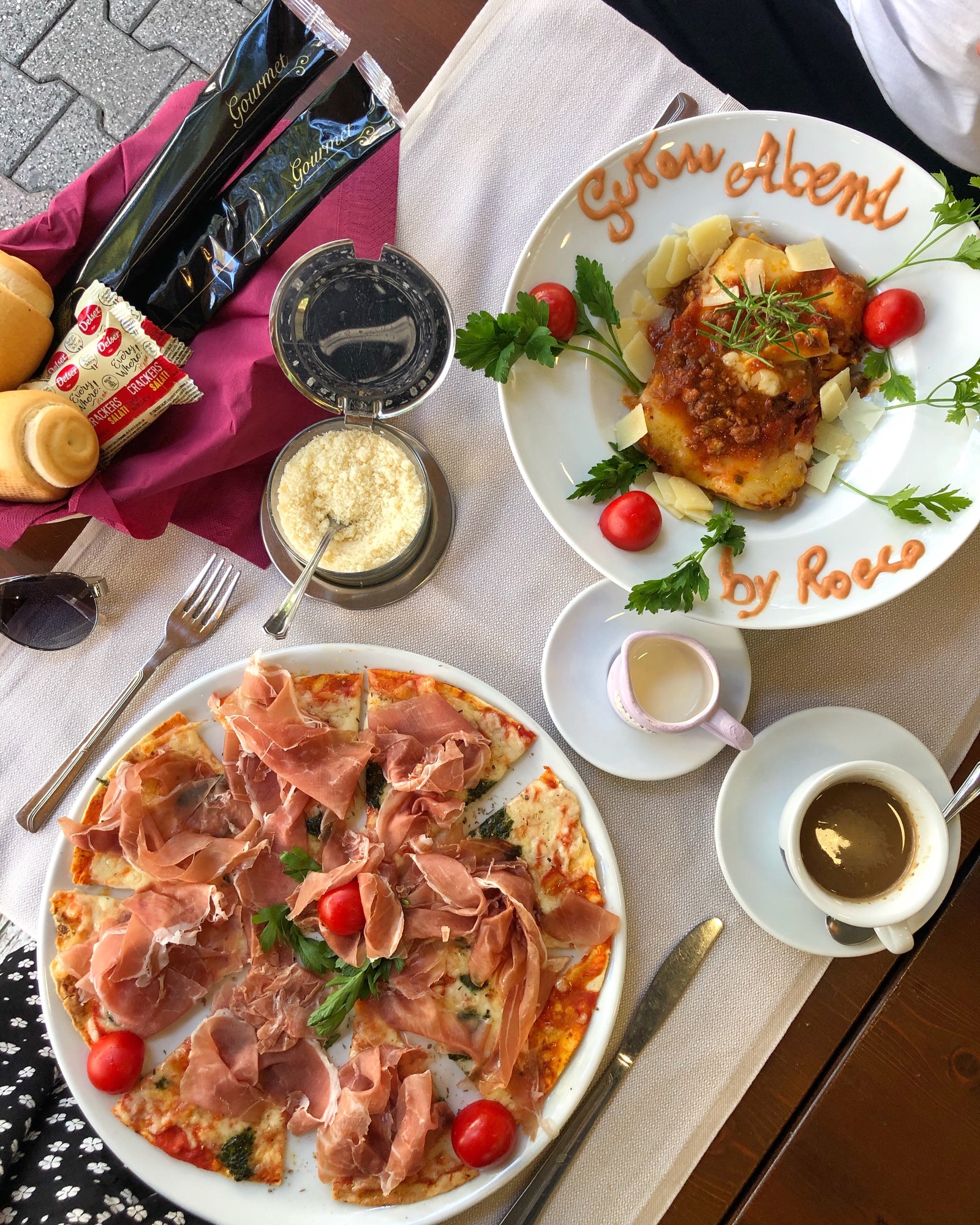 Hay dos platos de comida sobre una mesa con una taza de café (plato, desayuno completo, desayuno, cocina italiana, brunch)