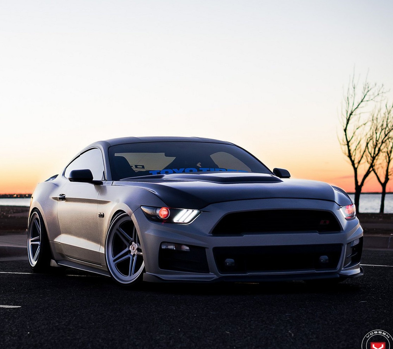 Gros plan d'une mustang garée dans un parking (voiture, ford mustang, muscle)