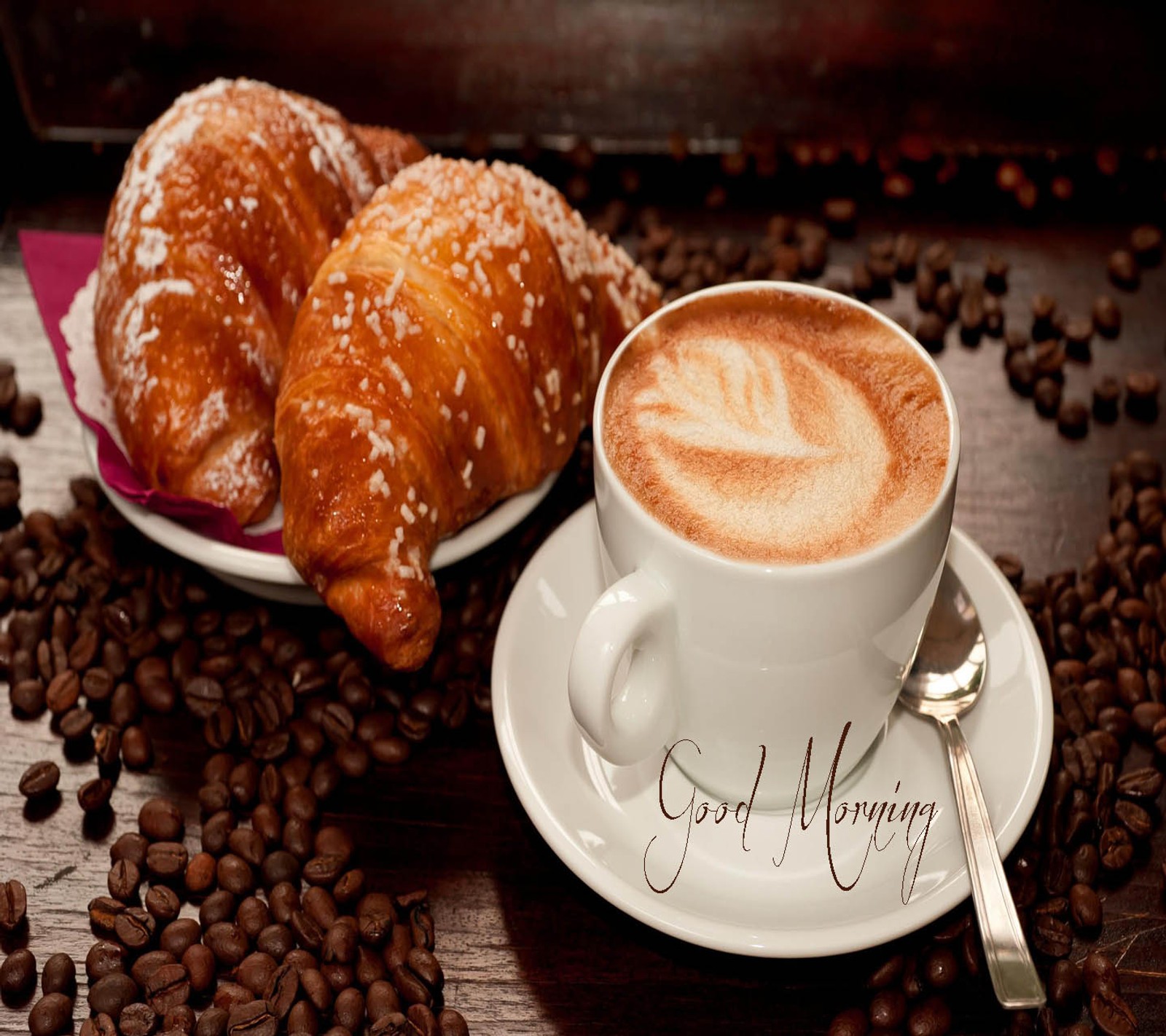 There is a cup of coffee and a plate of croissants (good, morning)