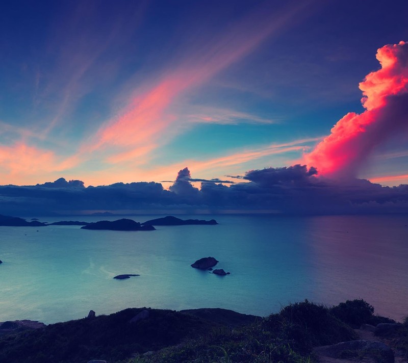 Una vista de una hermosa puesta de sol sobre el océano con una nube (arte, diseño)