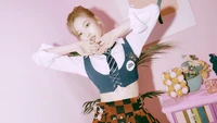 Sana de TWICE met en avant une énergie vibrante dans une tenue ludique et stylée sur un fond pastel.