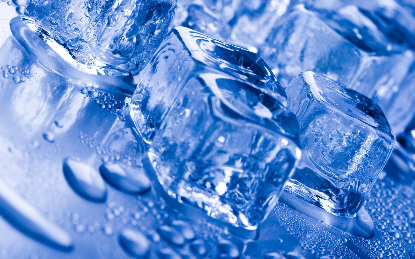 A close up of a bunch of ice cubes on a table (ice cube, blue, water, cobalt blue, ice)