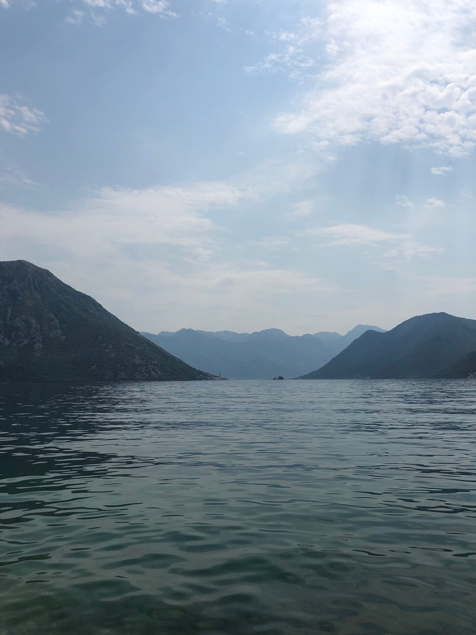 Un bateau flottant dans l'eau près de montagnes (formes montagneuses, chaîne de montagnes, ressources en eau, nuage, hauts plateaux)