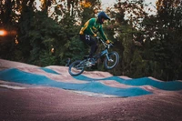 Piloto de BMX realizando un truco en una pista de bombeo